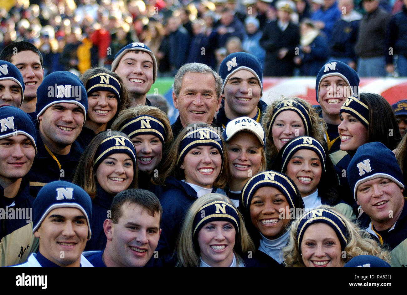 2004 - Il presidente statunitense George W. Bush huddles con le cheerleaders dalla US Naval Academy (USNA) in disparte durante le cerimonie di apertura per il 105° Army vs Navy gioco. La Marina Guardiamarina sconfitto esercito 42 a 13. Foto Stock