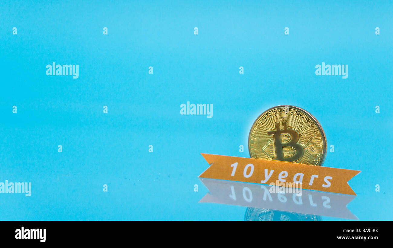 Bitcoin festeggia i dieci anni di anniversario, coin con dieci anni segno, con copia blu spazio Foto Stock