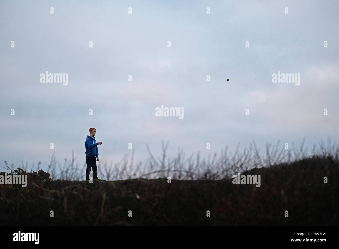 Un ragazzo adolescente giocando in un campo. Foto Stock