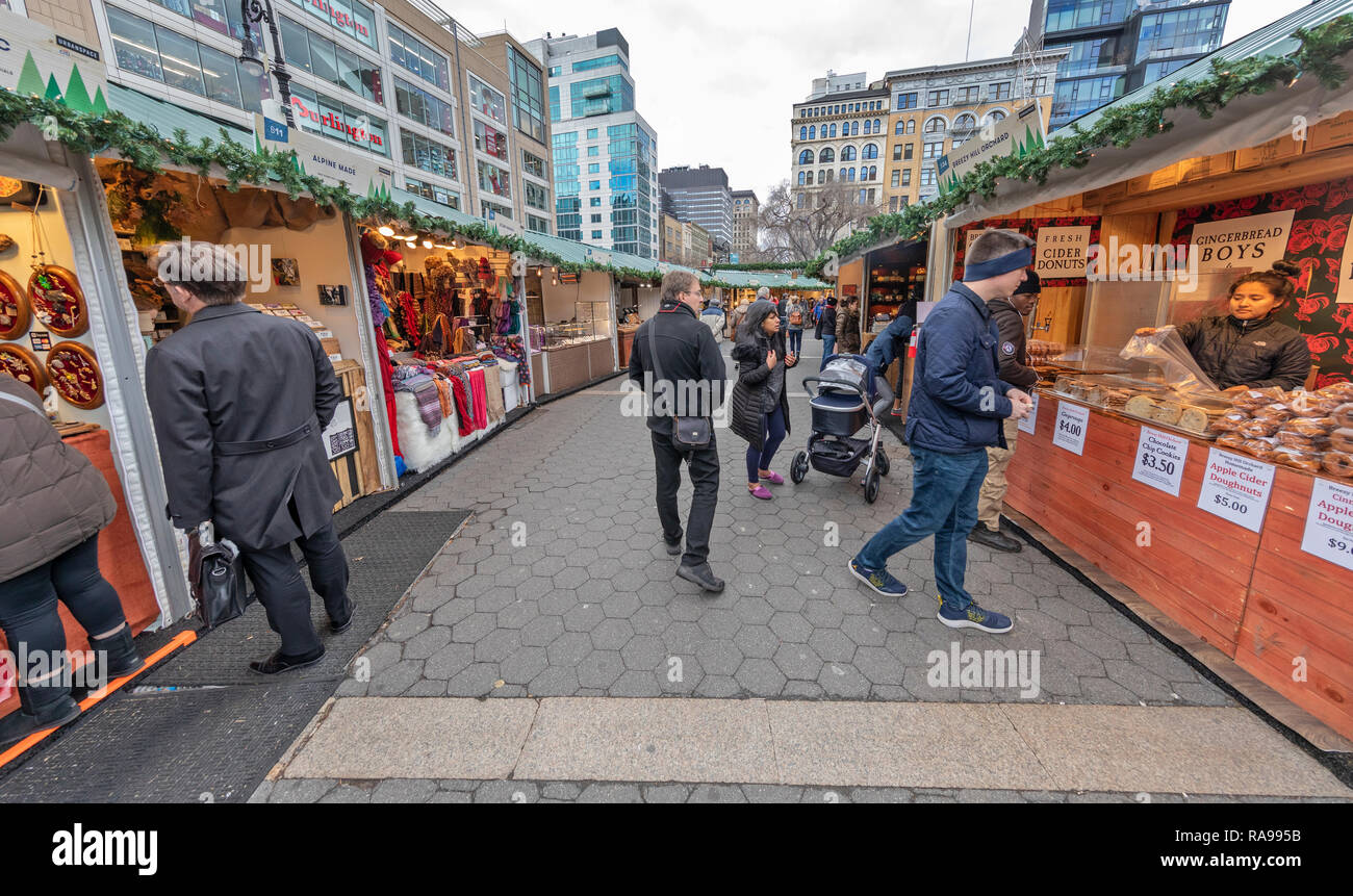 Gli acquirenti e i turisti ad esplorare l'Unione Piazza Mercato vacanze in Union Square di New York City. Foto Stock