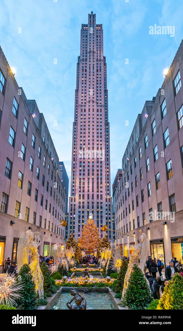 L'albero di Natale al Rockefeller Center circondato dagli angeli, turisti, visitatori e gli edifici. Foto Stock