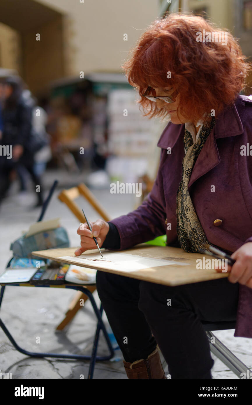 City street scene: femmina pittore presso la piazza di Firenze, Italia Foto Stock