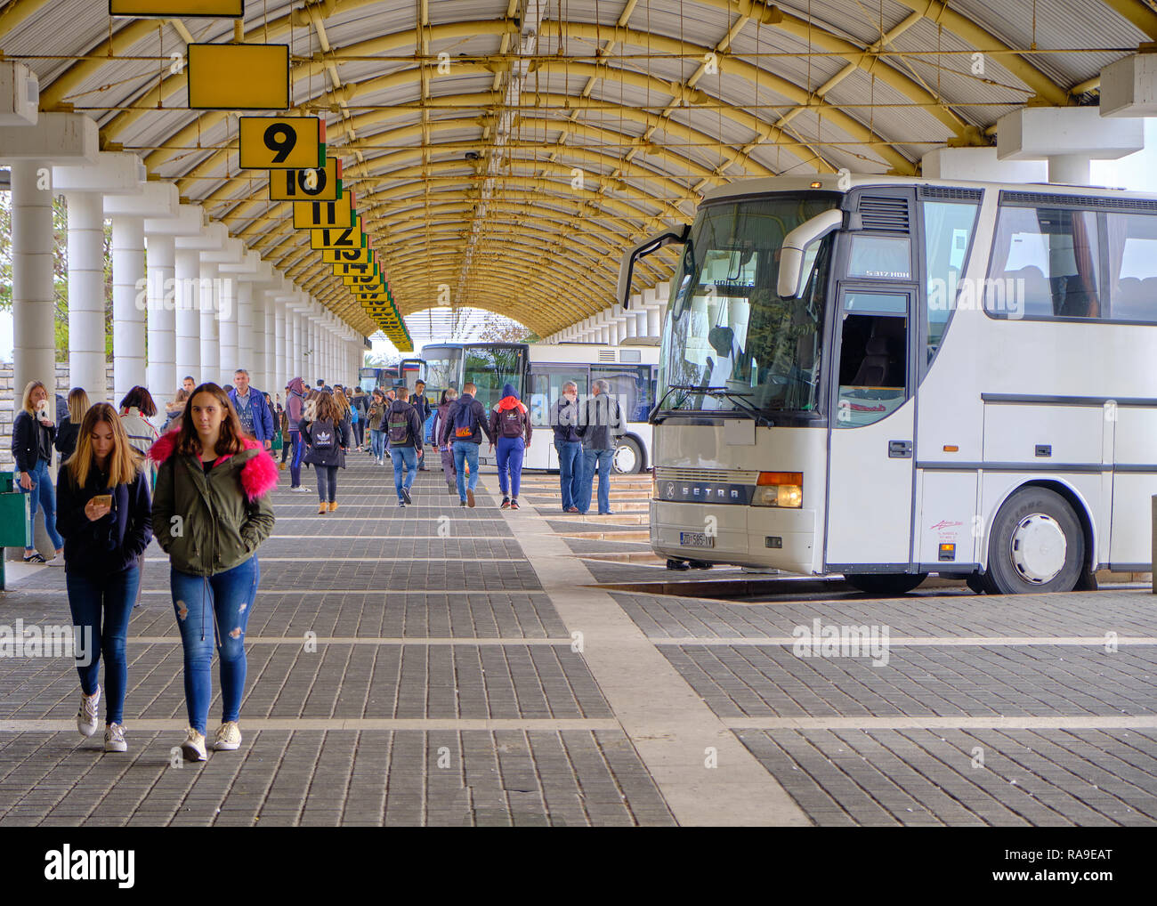 La lunga distanza bus terminal della piattaforma 9 e, con il bus in attesa e i passeggeri in arrivo, portando la linea dei numeri e arcuata architettura a cupola Foto Stock