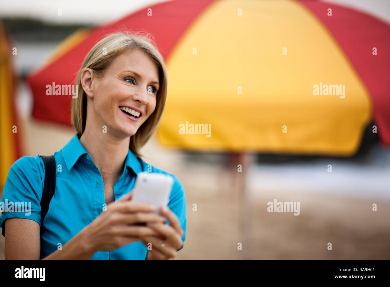 Imprenditrice sorridente in possesso di un telefono cellulare. Foto Stock