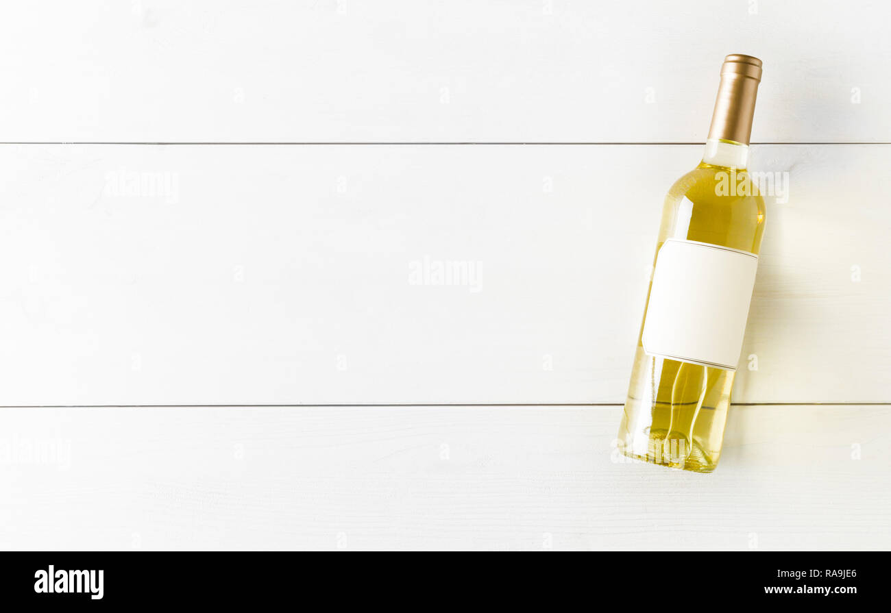 Bianco bottiglia di vino bianco sul tavolo di legno piana da laici al di sopra con lo spazio di copia Foto Stock