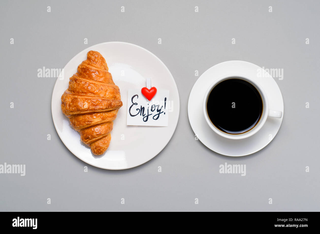 Pane appena sfornato, croissant, caffè e gustare nota su sfondo grigio, colazione concetto, vista dall'alto Foto Stock