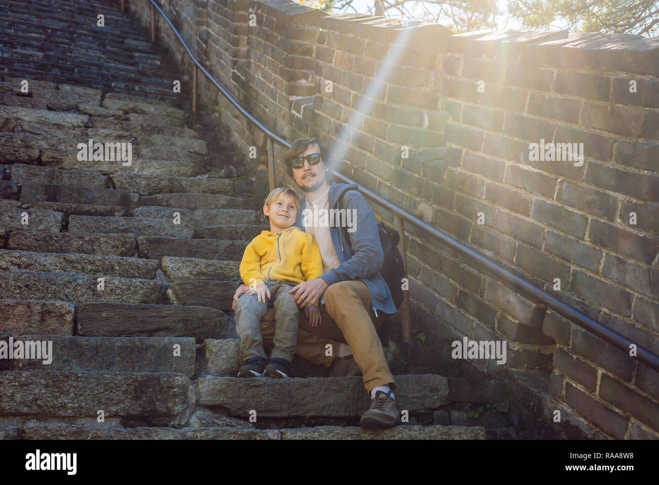 Felice allegro gioioso turisti papà e figlio presso la Grande Muraglia della Cina divertirsi sul viaggio sorridente ridendo e ballando durante il viaggio in Asia. Destinazione cinese. Viaggiare con i bambini in Cina concept Foto Stock