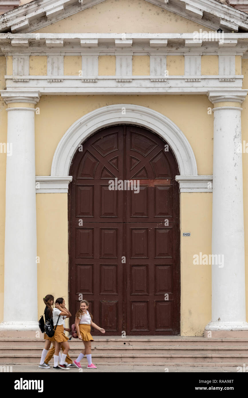 Studentesse a piedi nella parte anteriore del Collegio San Lorenzo, Plaza José Marti, Cienfuegos, Cuba Foto Stock