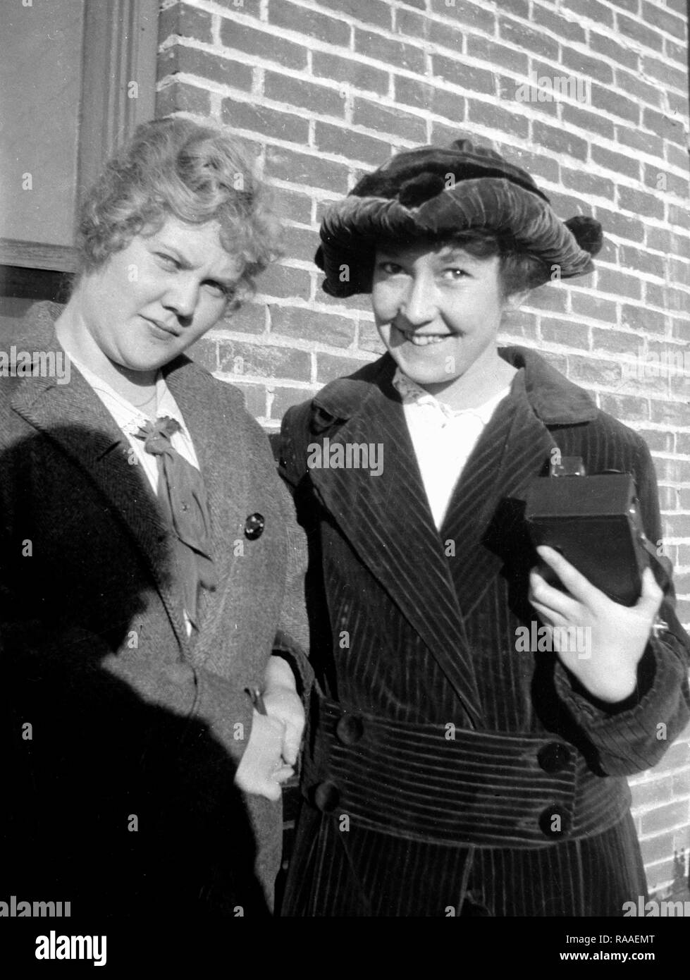 Due donne pongono insieme contro un muro di mattoni,ca. 1928. Foto Stock