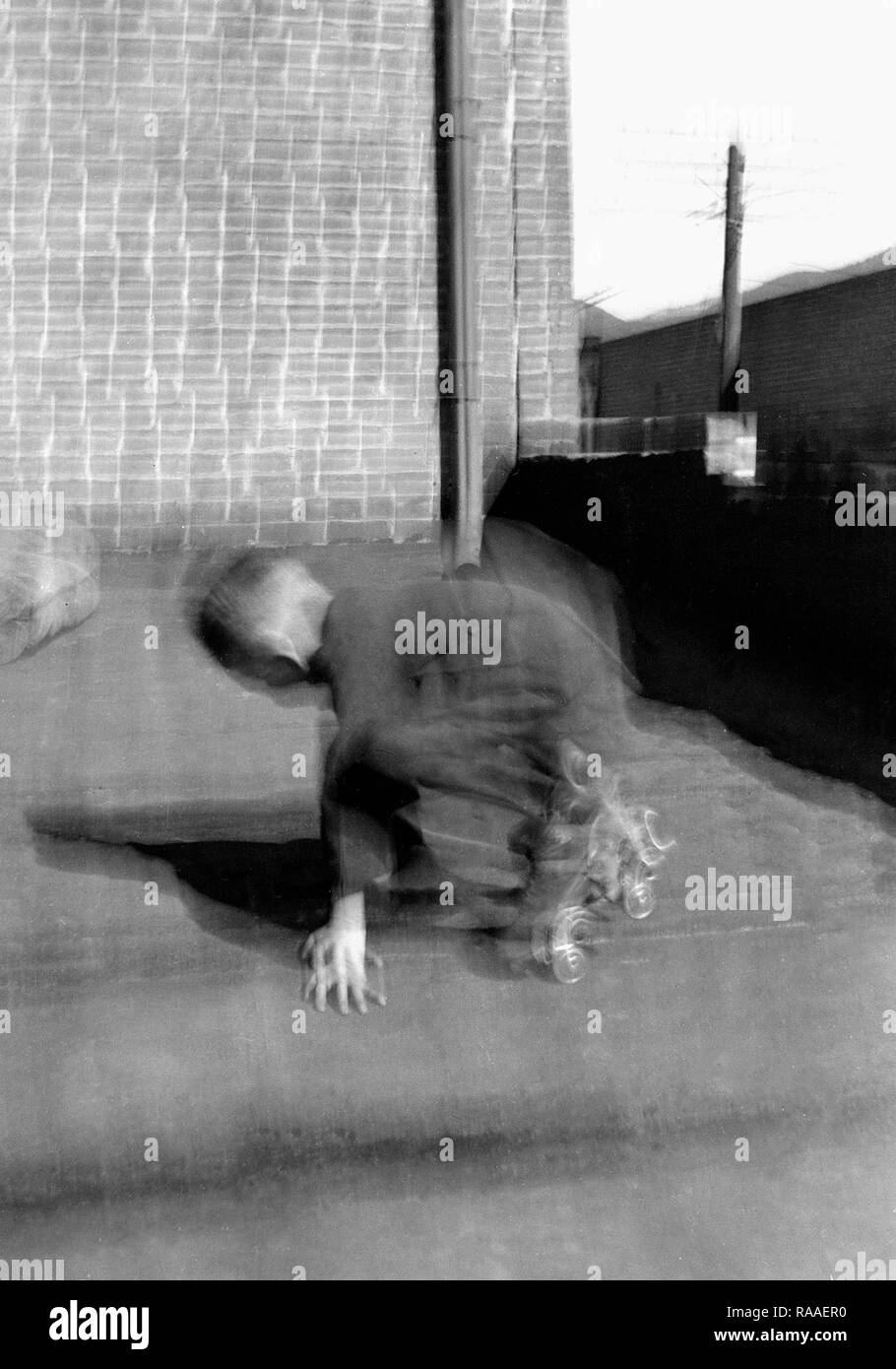 Un giovane ragazzo è una sfocatura mentre pattinaggio su un tetto, ca. 1925. Foto Stock