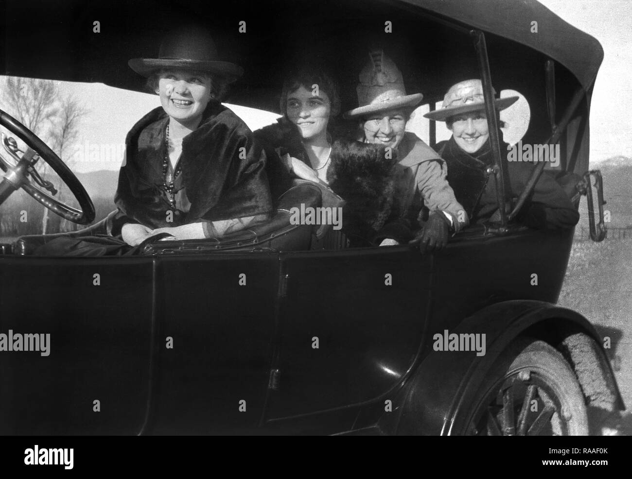 Quattro donne cram in un periodo in automobile per un viaggio su strada, ca. 1928. Foto Stock