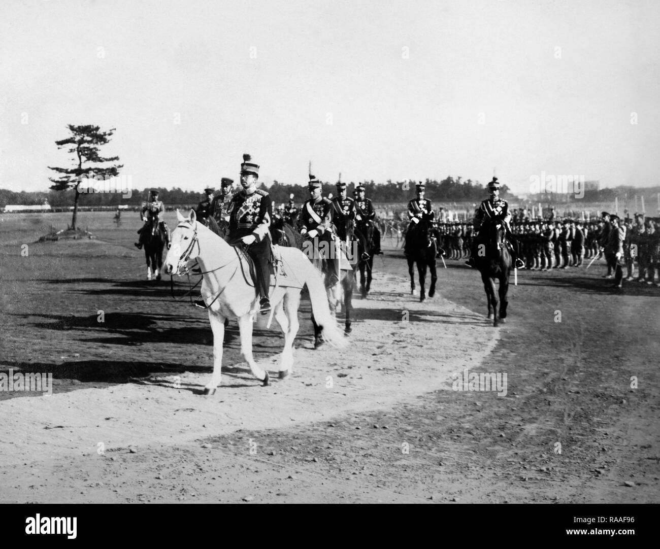 Imperatore giapponese Hirohito recensioni truppe a bordo del suo stallone imperiale Shirayuki, ca. 1933. Foto Stock