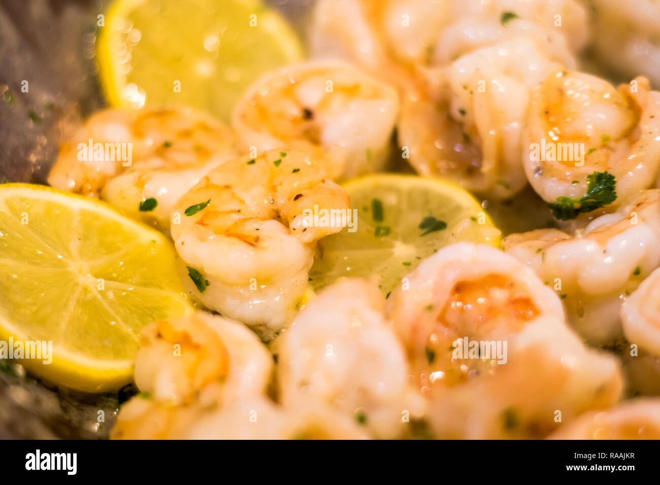 La deliziosa e leggera Scampi saltate in padella con il burro, limone, aglio, peperoncino rosso e di prezzemolo fresco Foto Stock