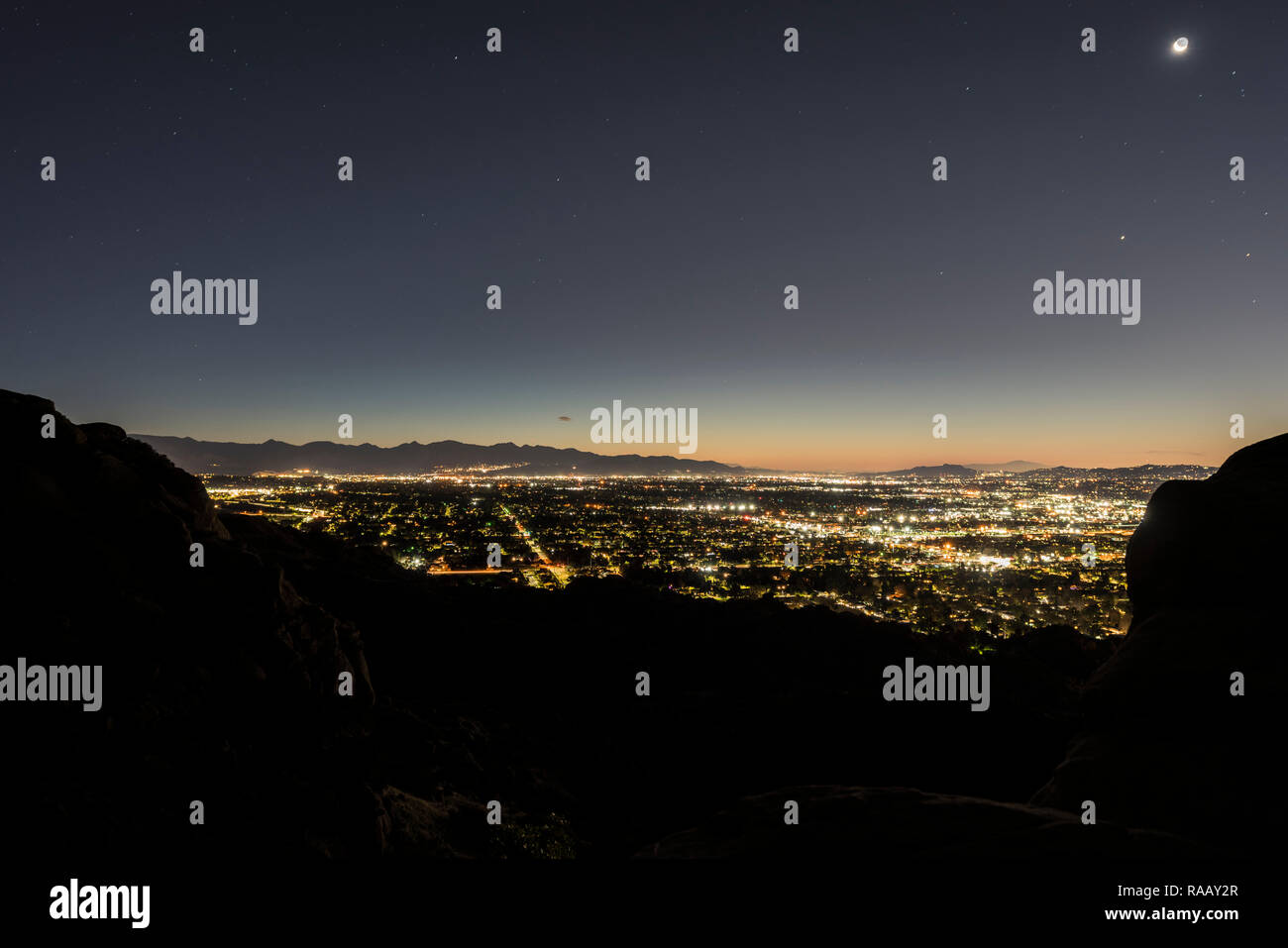 Vista Predawn tentacolare di San Fernando Valley Ovest i quartieri da picchi rocciosi in Santa Susana montagne sopra di Los Angeles, California. Foto Stock