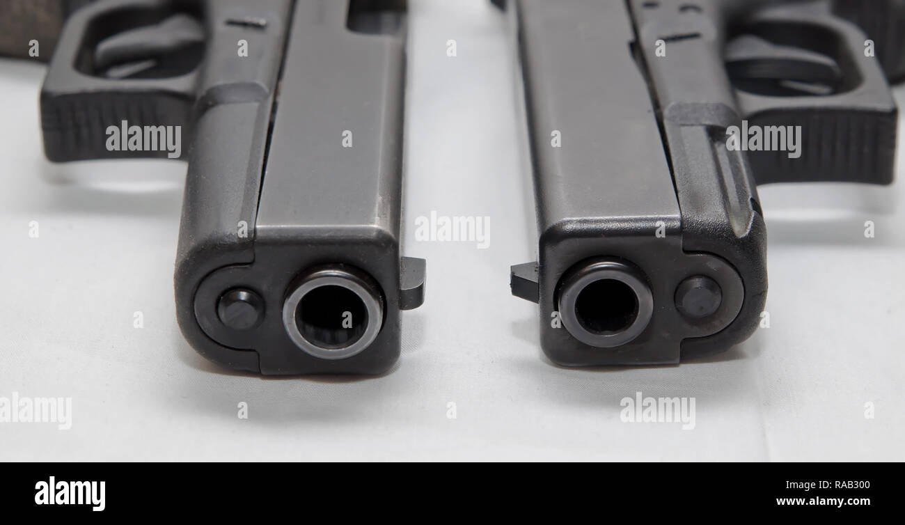 Due nero semi pistole automatiche, a 9mm e un calibro 40 su uno sfondo bianco che mostra le diverse dimensioni di loro Foto Stock