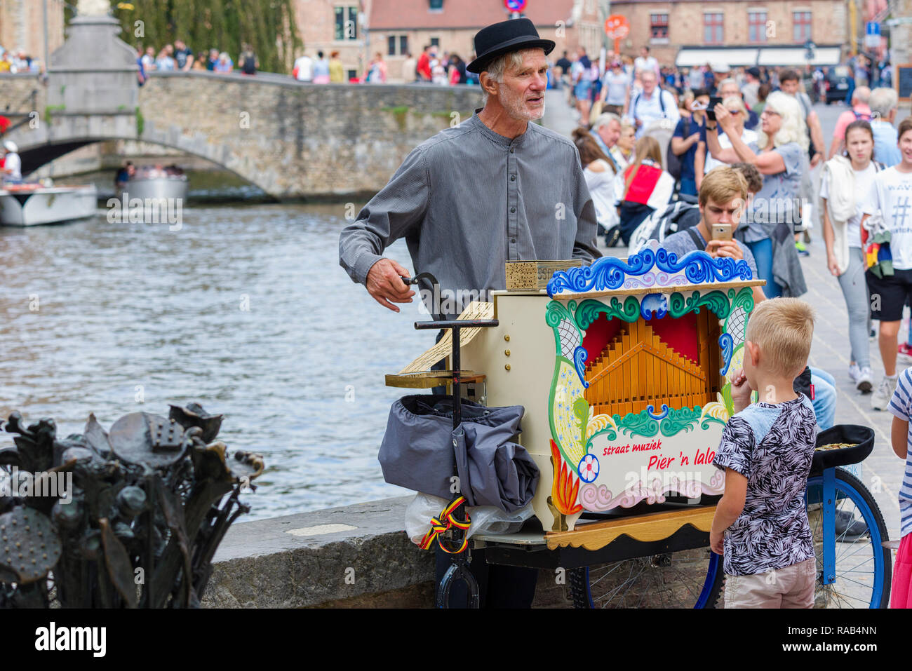 Portatile lettore di organo lungo un canale belga a Bruges, Belgio Foto Stock