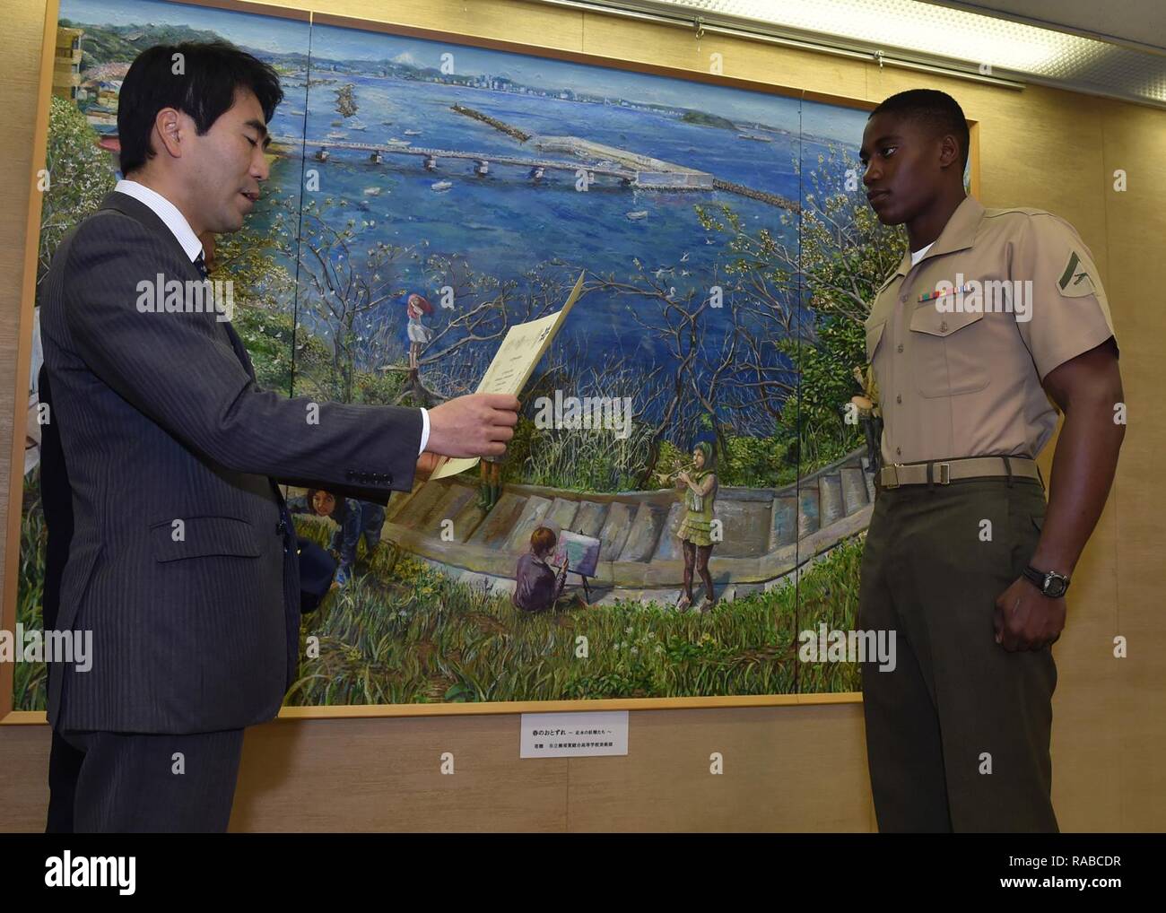 Stati Uniti Lancia Marine Cpl. Raheem Gilliam riceve un certificato da Yokosuka Sindaco Yuto Yoshida Lunedì, gen. 16, 2017 a Yokosuka City Hall, Giappone, per la sua risposta istintiva e azioni eroiche di recuperare una famiglia in cui il veicolo è scesa dal quinto piano di un garage per il parcheggio in Ogawa- cho, Yokosuka, Dic 31, 2016. Gilliam era uno dei sette persone aggiudicati per azioni eroiche. Egli è assegnato al 3° Battaglione, 1° Reggimento Marini, 1° Divisione Marine e distribuito ai 3° Divisione Marine, III Marine forza expeditionary basato a Okinawa, Giappone. Foto Stock