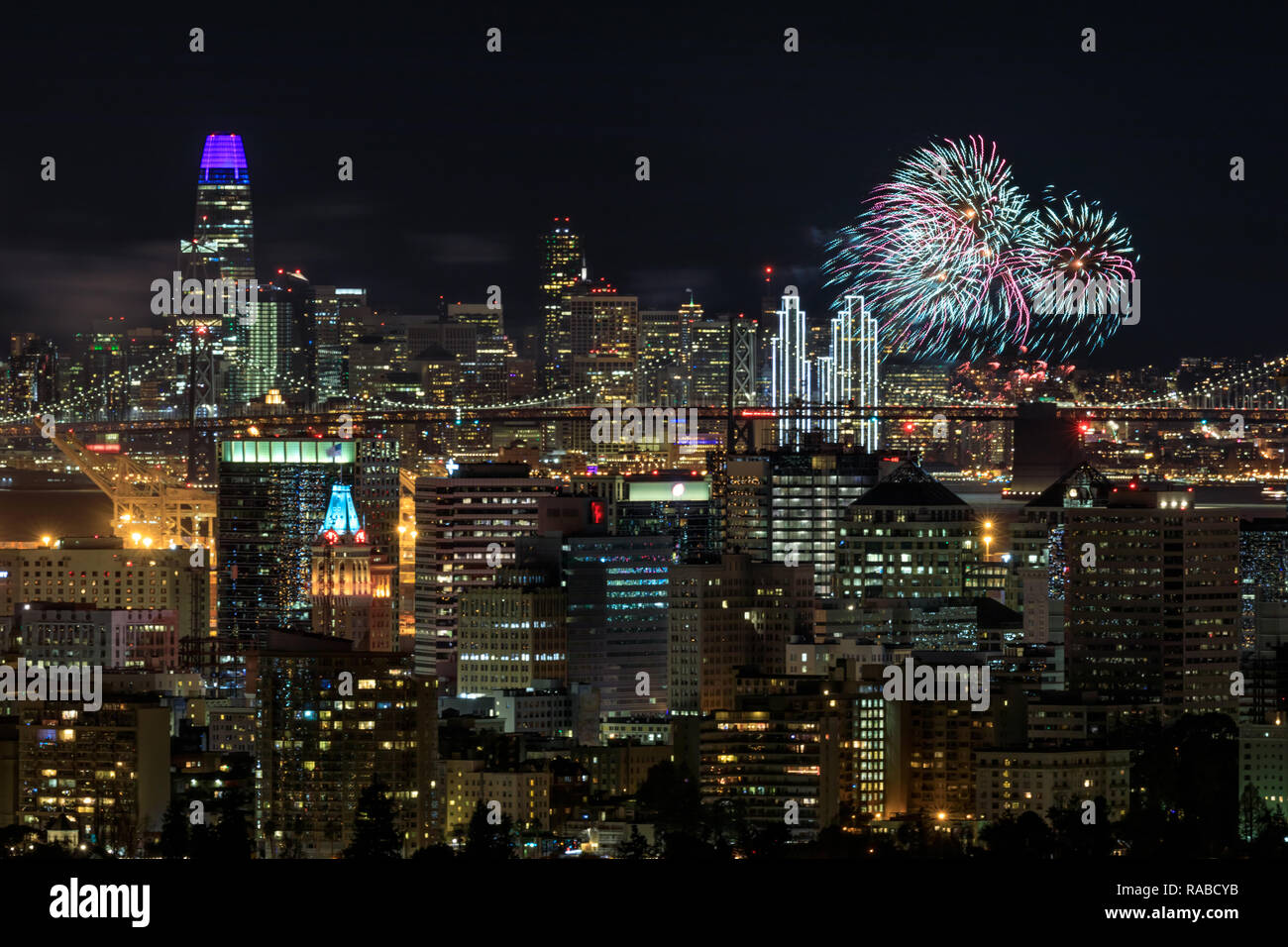 Oakland e San Francisco Downtowns con Capodanno 2019 fuochi d'artificio. Foto Stock