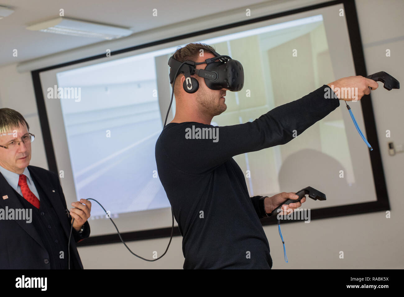 12 novembre 2018, Renania settentrionale-Vestfalia, Köln: Treno attendant Daniel von Contzen (r) e la testa della pratica Volker Lange pratica utilizzando la realtà virtuale per azionare un built-in sollevamento sulle porte di un ICE4 per gli utenti di sedia a rotelle durante una sessione di formazione con la realtà virtuale. Dal 2018, virtuale e la realtà aumentata è stata parte integrante della Deutsche Bahn di formazione e di istruzione ulteriore programma. (A dpa "realistico e sicuro: le aziende fanno affidamento sulla realtà virtuale formazione" dal 03.01.2019) Foto: Rolf Vennenbernd/dpa Foto Stock