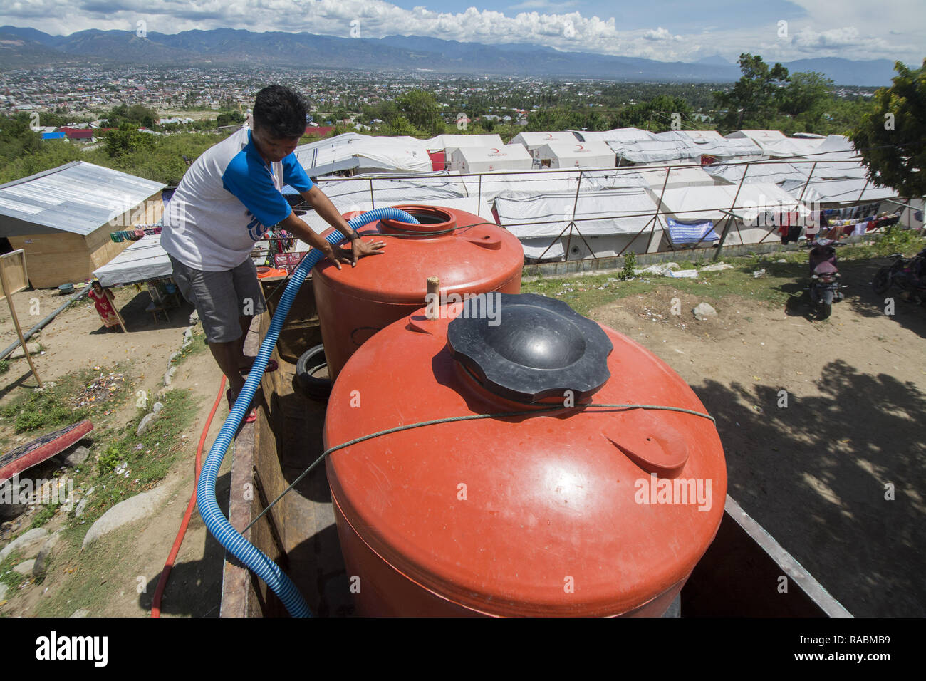 Palu, Sulawesi centrali, Indonesia. 3 gennaio 2019. Lavoratori riempire di acqua pulita per i campi profughi in Balaroa, Palu, Sulawesi centrali Villaggio Camp integrato, Indonesia, giovedì (1/3/2019). Dopo essere entrato in un prolungamento della fase di emergenza o tre mesi dopo il disastro, i rifugiati hanno cominciato a sentire la difficoltà di acqua pulita in quanto l'alimentazione dai volontari era in calo e nel frattempo non ci sono state fonti di acqua in campo. Credito: bmzIMAGES/Alamy Live News Foto Stock