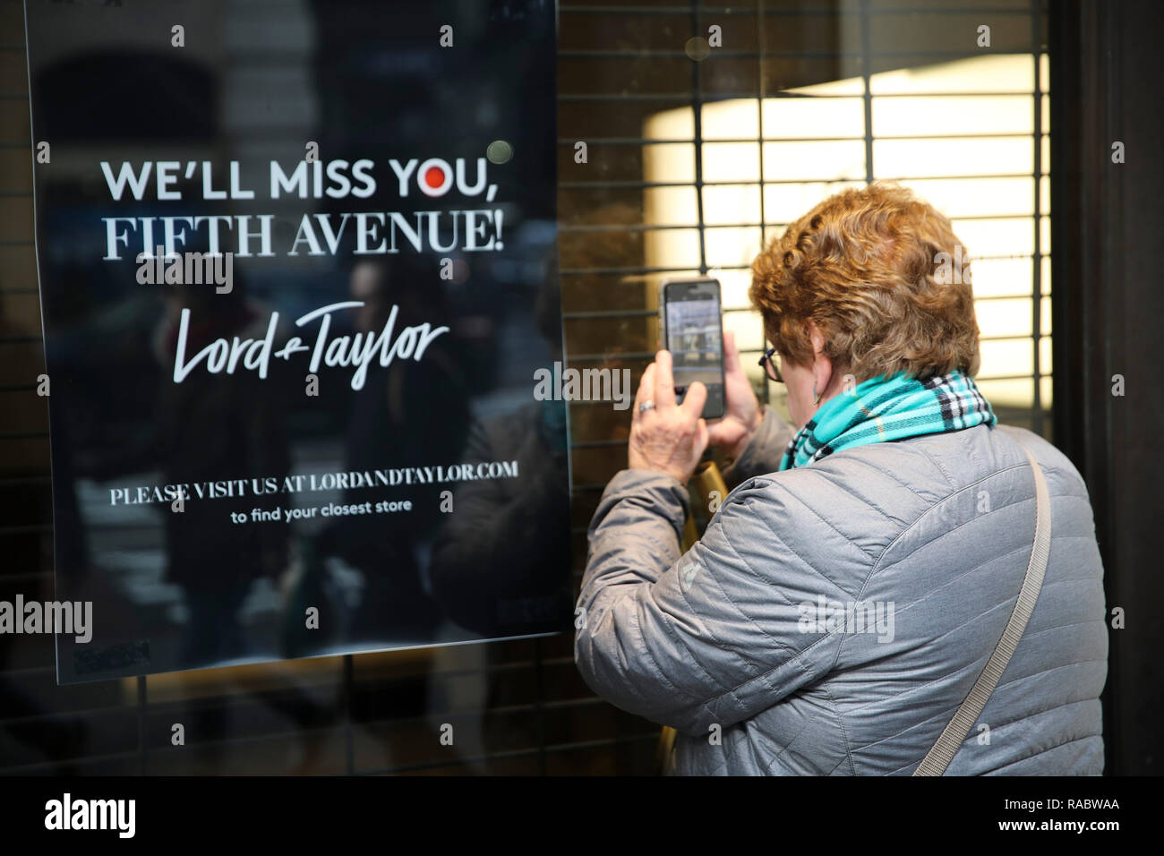 New York, Stati Uniti d'America. 3 gennaio, 2019. Una donna prende le foto attraverso una finestra chiusa di Lord & Taylor flagship store sulla Fifth Avenue a Manhattan, New York City, Stati Uniti a Gennaio 3, 2019. Il famoso grande magazzino catena Signore & Taylor chiuso ufficialmente la sua flagship store sulla Fifth Avenue a Manhattan. Il 11 piani è stato un punto di riferimento a New York la più prestigiosa area commerciale per oltre un secolo, vanta circa la sua vacanza animata windows e raffinata selezione di gioielli e abbigliamento e attirare degli abitanti della città e per i turisti. Credito: Wang Ying/Xinhua/Alamy Live News Foto Stock