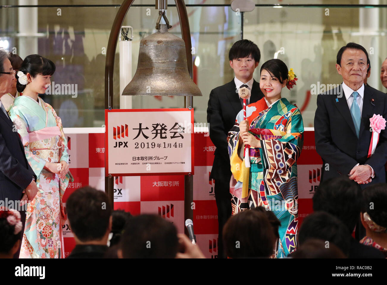 Tokyo, Giappone. 4 gennaio, 2019. Una donna in abiti kimono squilla una campana durante una cerimonia organizzata per celebrare il primo giorno di negoziazione del 2019 presso la Borsa di Tokyo il Venerdì, 4 gennaio 2019, mentre il Ministro delle finanze giapponese Taro Aso (R) guarda a. La quota del Giappone è i prezzi sono diminuiti 607.37 yen per chiudere a 19,407.40 yen presso la sessione mattutina della Borsa di Tokyo. Credito: Yoshio Tsunoda/AFLO/Alamy Live News Foto Stock