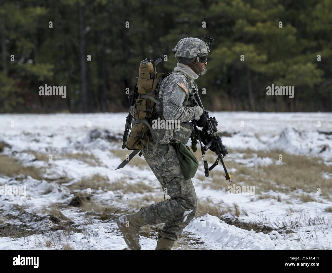 Un New Jersey Esercito Nazionale soldato di guardia con l'1-114th fanteria corre verso la woodline dopo un inserimento di aria dalla Marine Aircraft Group 49 UH-1Y Huey elicotteri durante una formazione congiunta esercita su base comuneGuire-Dix Mc-Lakehurst, N.J., 10 gennaio, 2017. Il Marine Corps riserva prevista airlift e chiudere il supporto aereo alla società alfa di soldati di 1-114. Il 1-114, che è parte del cinquantesimo della brigata di fanteria combattere Team, sta partecipando a una serie di eventi formativi che culmineranno questa estate in un combattimento esportabile capacità di formazione esercitare sulla Fort Pickett, Va. l esercito nazionale gua Foto Stock