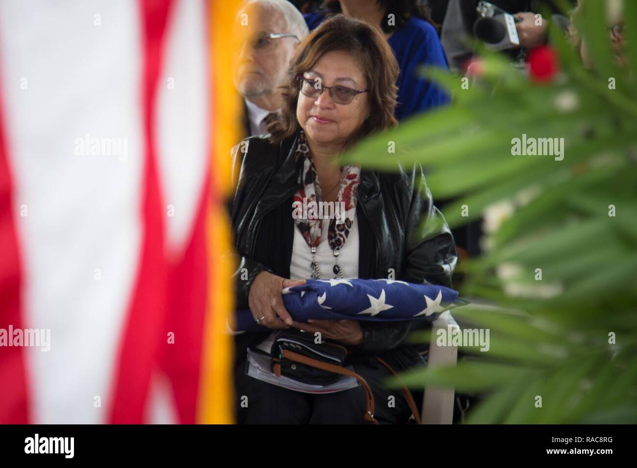 Pilar Jiminez afferra una bandiera americana ha presentato a lei in onore di suo fratello, 1969 Congressional Medal of Honor destinatario U.S. Marine Corps Lance Cpl. José Francisco Jimenez, durante il confino di Jimenez a Phoenix il Jan 17, 2017. Jimenez, originariamente un nativo del Messico, si trasferì con la famiglia a Red Rock, Ariz. quando aveva dieci anni. Jimenez andò a unirsi al Marine Corps dopo la laurea di alta scuola in 1968, prima per poi essere spediti alla Repubblica socialista del Vietnam nel febbraio del 1969. In Agosto di 1969, Jimenez è stato ucciso in azione su postumo riceve la medaglia di Honor fo Foto Stock