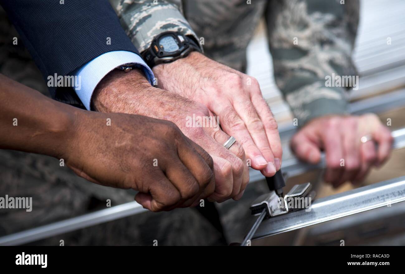 Mike Burrows, Golfo di potenza, De Feo, Coronale Servizi di sviluppo e Col. Craig Johnson, 96ala prova, contemporaneamente girare la chiave per installare un pannello solare in una piccola cerimonia gen. 18 a Eglin Air Force Base, Fla. leader dei tre partner di progetto, ha installato la prima della eventuale 375.000 pannelli solari che sarà situato su 240 acri di terreno. Foto Stock