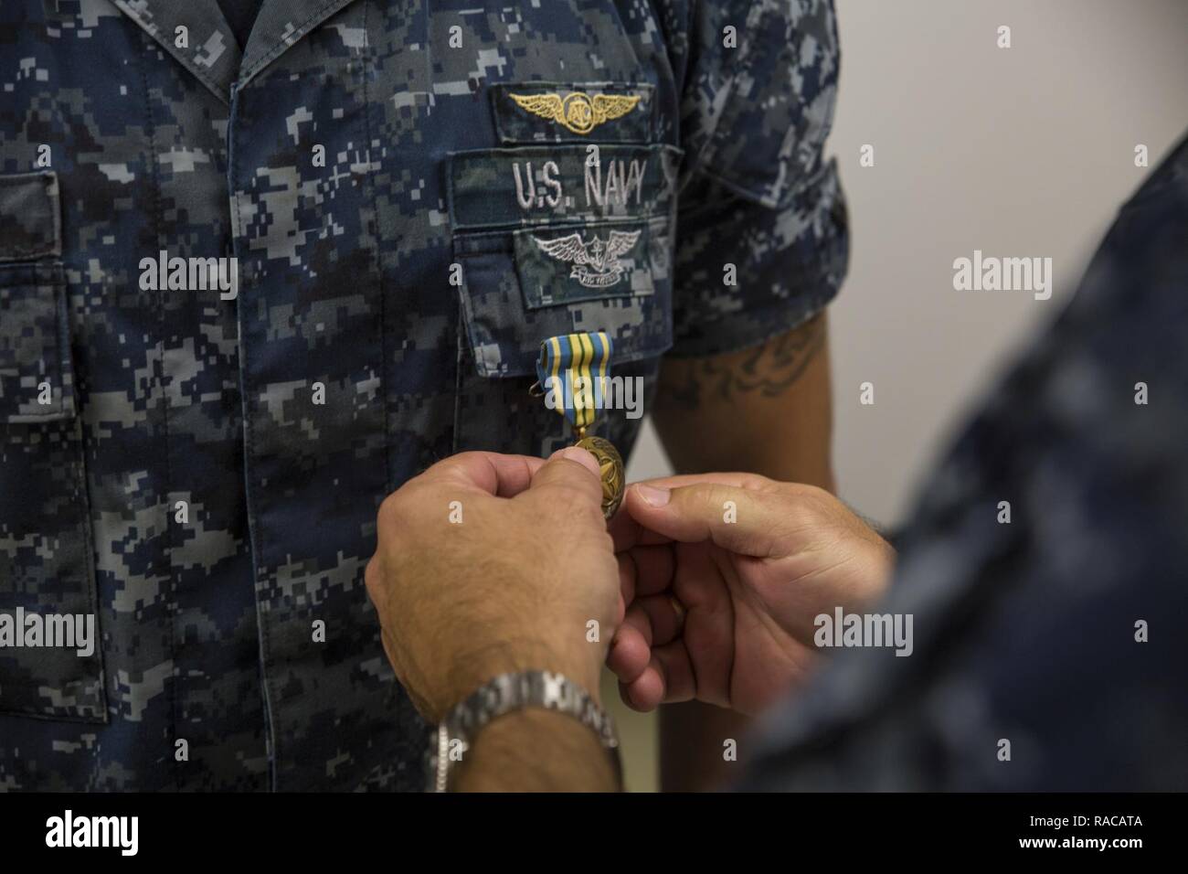 MARINE CORPS BASE HAWAII - Adm posteriore. John Weigold, la riserva di vice comandante con U.S. Flotta del Pacifico, presenta un militare eccezionale servizio di volontariato medaglia da Petty Officer 1. Classe Brandon Thompson, un capo equipaggio con la flotta di supporto logistico Squadron 51, e un nativo di Bonners Ferry, Idaho, durante una cerimonia di premiazione tenutasi a Hangar 5 a bordo del Marine Corps Air Station Kaneohe Bay, Marine Corps base Hawaii, a gennaio 18, 2017. Weigold visitato VR-51 come parte di un tour isola di riserva di unità navali in cui egli ha interagito con i marinai, riuniti gli uomini e le donne sotto il suo comando. Foto Stock