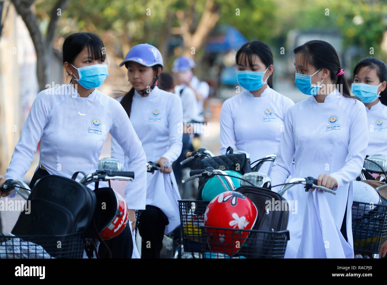 Gli studenti vestito in Ao Dai sulla strada per la scuola, Cai Be, Vietnam, Indocina, Asia sud-orientale, Asia Foto Stock