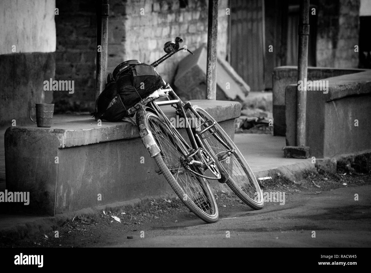 Una vecchia bicicletta si appoggia a un edificio abbandonato nelle zone rurali dello Zimbabwe. Foto Stock
