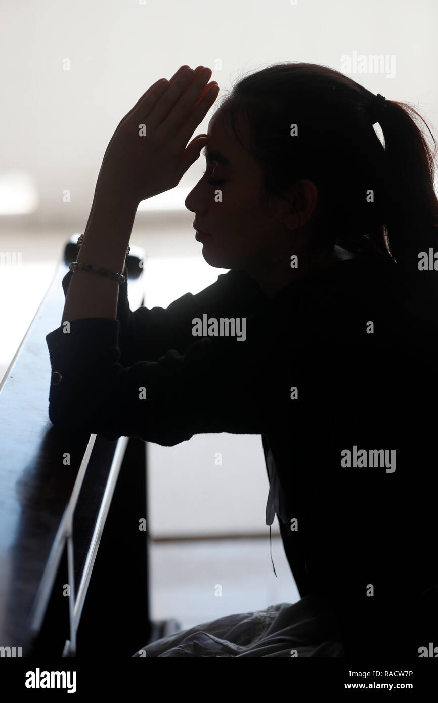 Silhouette di donna che prega in una chiesa, in Vietnam, in Indocina, Asia sud-orientale, Asia Foto Stock