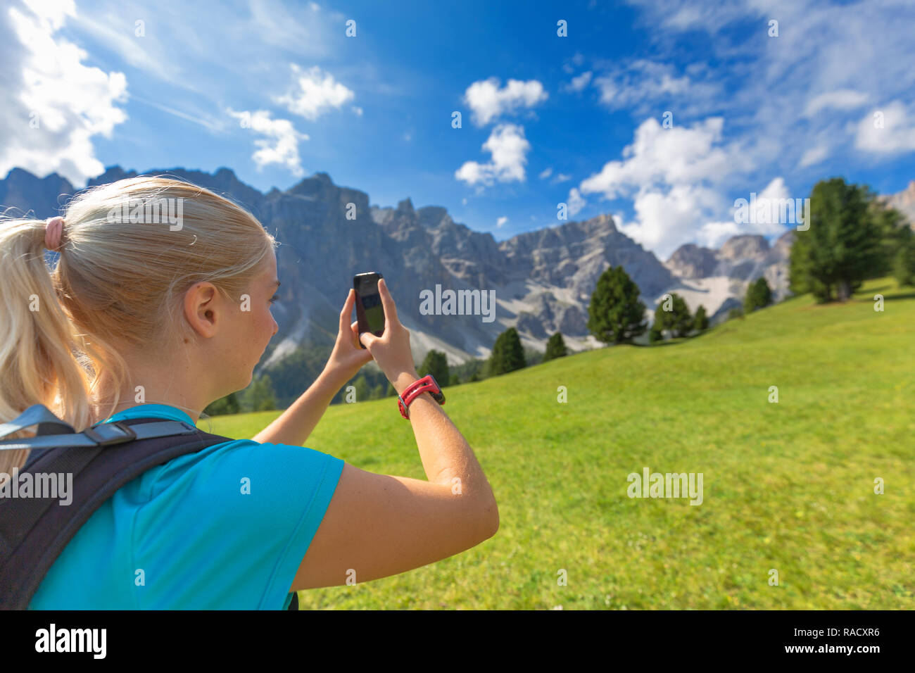 Ragazzina prende una foto con uno smartphone, Longiaru, Val Badia Alto Adige, Dolomiti, Italia, Europa Foto Stock