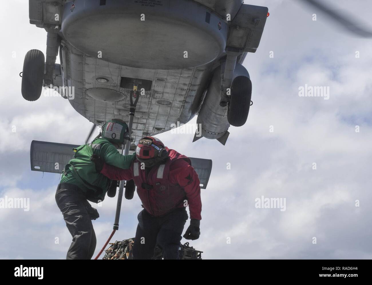 Oceano Pacifico (GEN. 30, 2017) Aviation Electronics tecnico di terza classe Kruegar Giacobbe (sinistra), da Seattle, Washington, mantiene un occhio sul gancio attaccati ad un MH-60R Sea Hawk elicottero attaccato ad un elicottero Maritime Strike Squadron 78 mentre Aviation Ordnanceman 1a classe Nick Gravesande, da Tecate, Messico, lo guida fuori da sotto l'elicottero durante un esercizio pratico per un futuro di rifornimento verticale in mare sul ponte di volo di Arleigh Burke-class guidato-missile destroyer USS Wayne E. Meyer (DDG 108). Wayne E. Meyer è su un regolarmente programmati Pacifico occidentale di implementazione con il Foto Stock