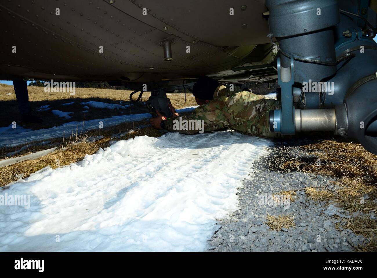 Un U.S. Paracadutista esercito dalla brigata 173rd battaglione di supporto, 173rd Brigata Aerea, controlli i ganci sotto uno sloveno Air Force Eurocopter H3-74 prima di una imbracatura operazione di carico durante la fase di esercizio Lipizzaner III in Pocek, Slovenia, Gennaio 27, 2017. Lipizzani è una squadra combinata di formazione a livello esercizio in preparazione per il plotone, di valutazione e di convalida del battaglione a livello di procedure di distribuzione. Foto Stock