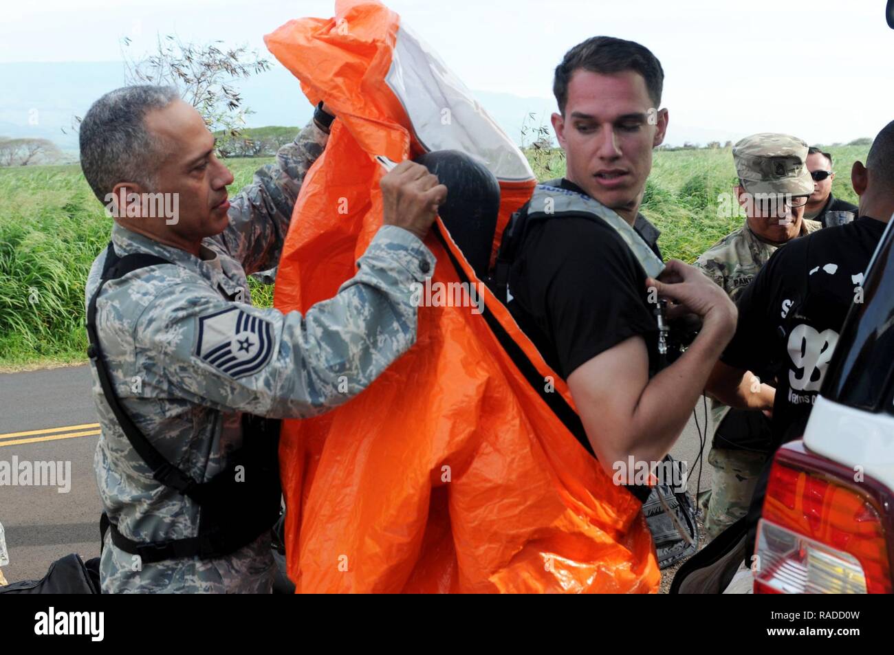 Master Sgt. Emilio Maldonado, 93civile il Team di supporto, Hawaii National Guard, Non-Commissioned medico ufficiale responsabile, assiste Sgt. Milo S.K. Kalama con il suo equipaggiamento protettivo personale prima di entrare in una possibile contaminazione durante la scena di un mondo reale esercizio presso l'Aeroporto di Kahului, Hawaii a gennaio 31, 2017. Il 93CST risponde per assistere i primi responder nella identificazione chimica, biologica, radioattiva e pericoli nucleari durante il Kai Malu O Hawaii esercitare sulla contea di Maui. Foto Stock