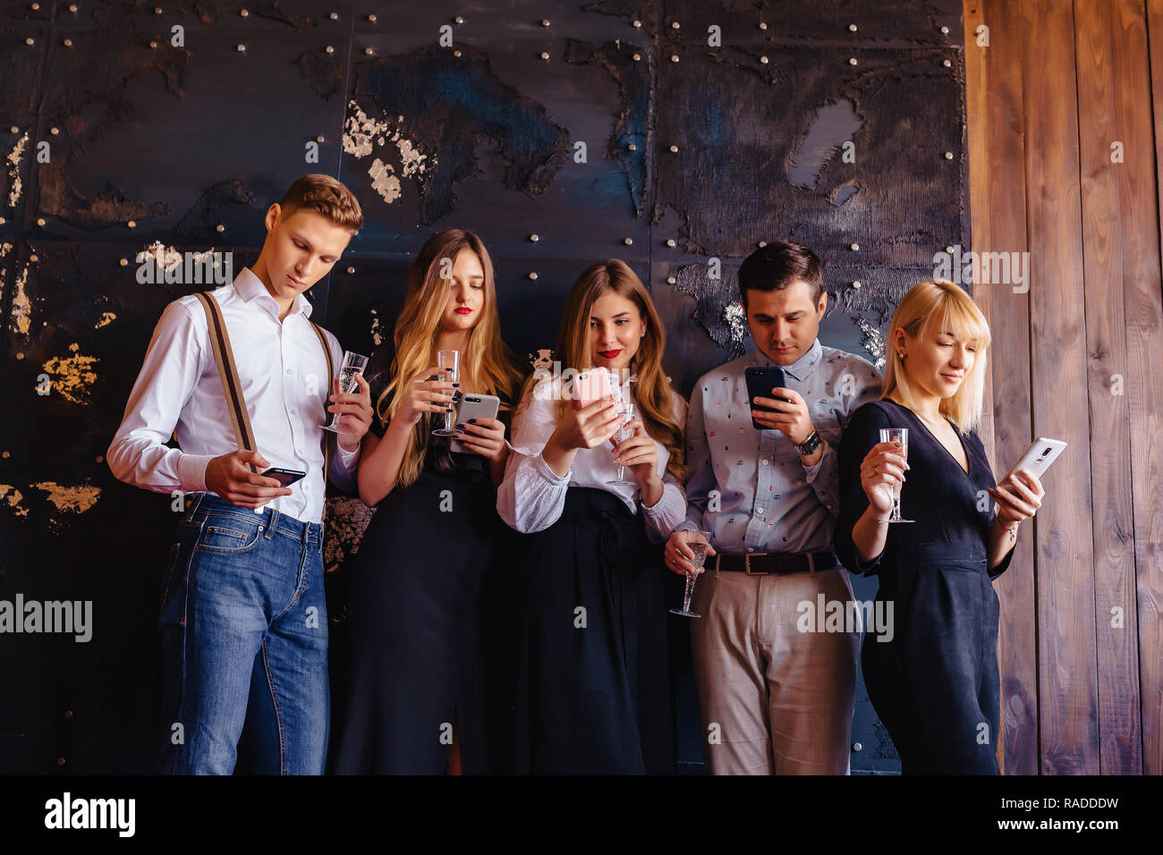 Grande azienda festeggia il nuovo anno con bicchieri di champagne con telefoni mania a casa Foto Stock