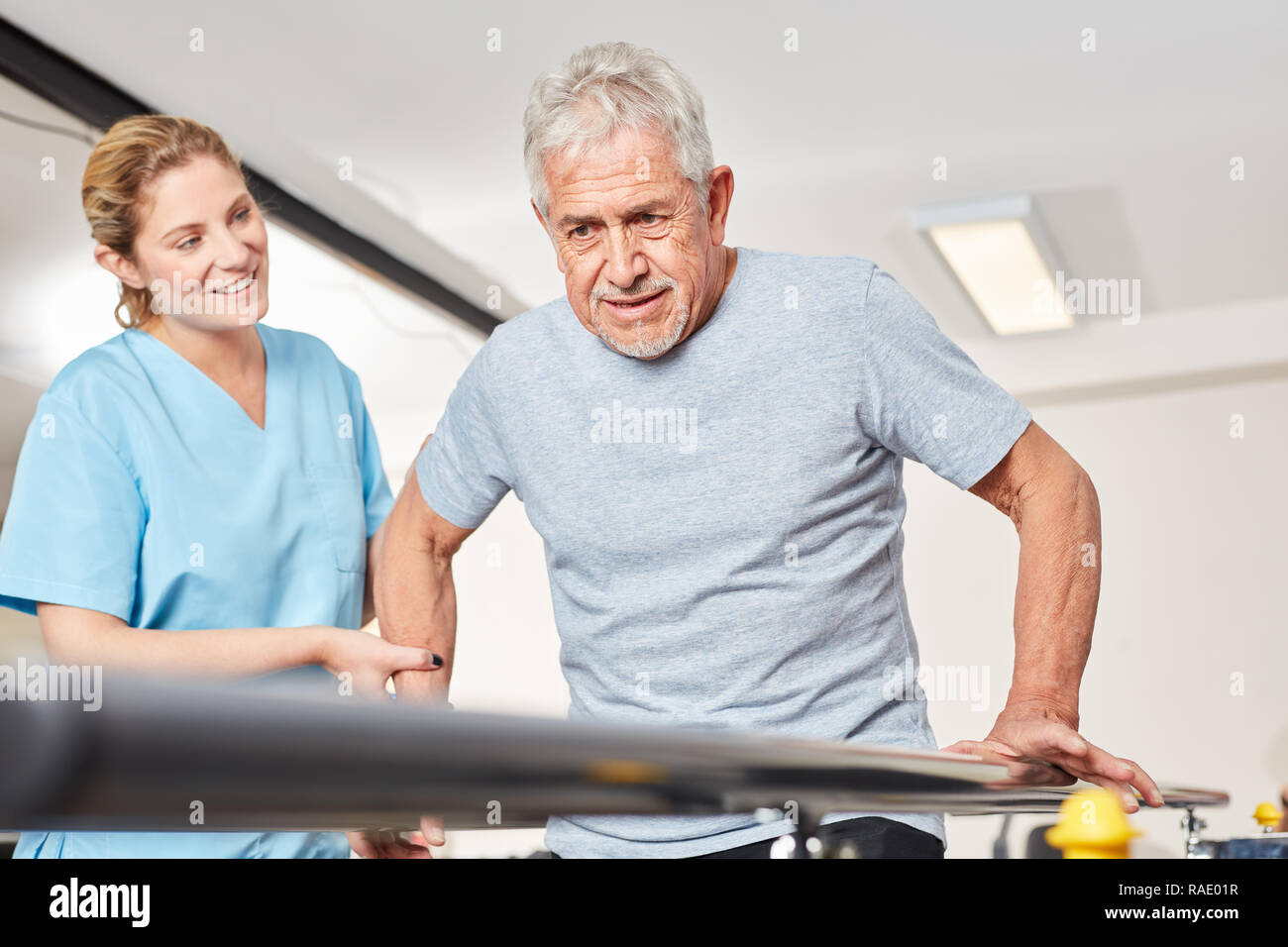 Senior uomo fa una terapia di movimento per la mobilità in rehab Foto Stock