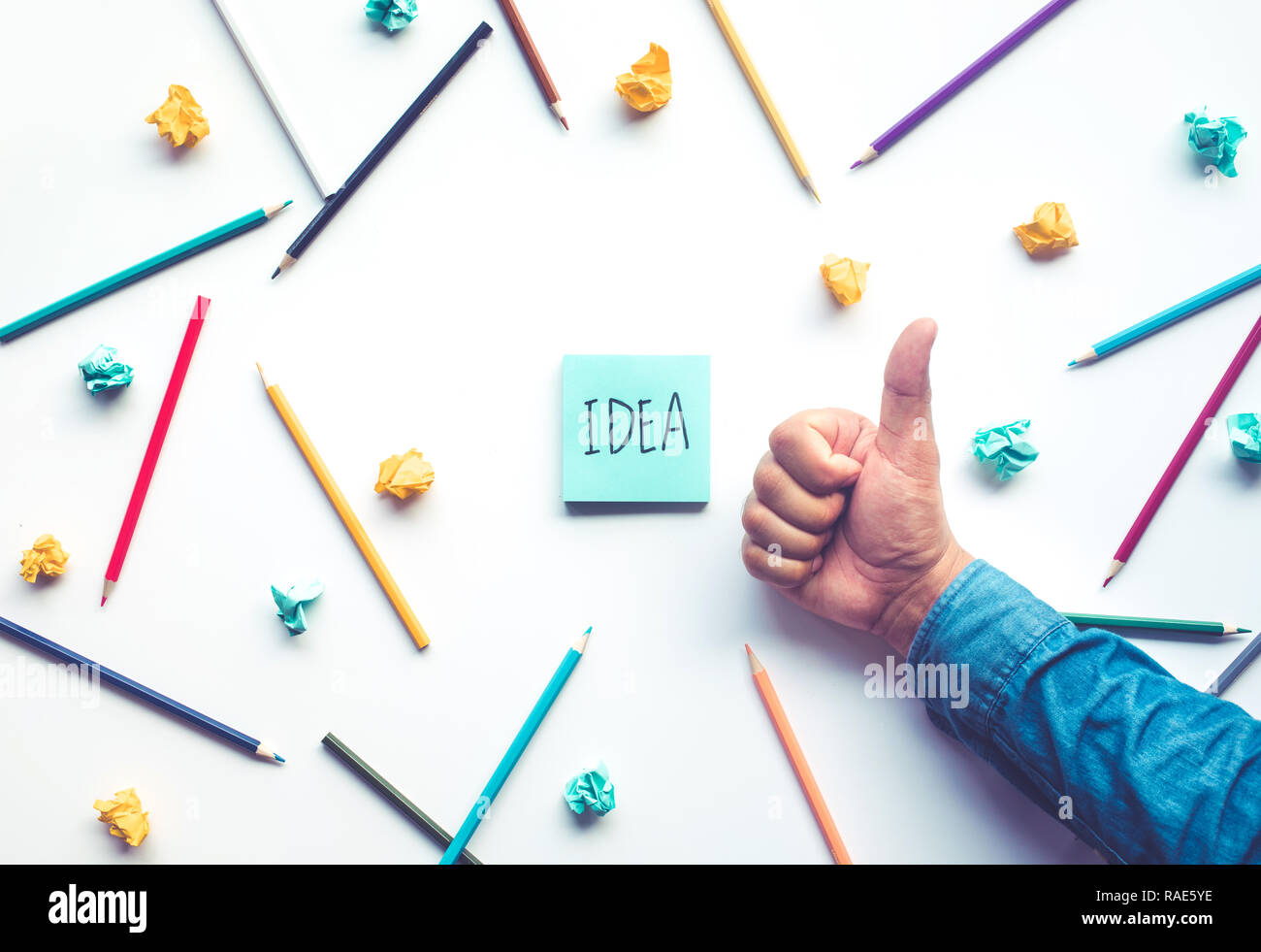 Imprenditore pollice alzato la mano per celebrare idea con matita e notepaper sul tavolo bianco.la creatività imprenditoriale e i concetti di istruzione Foto Stock