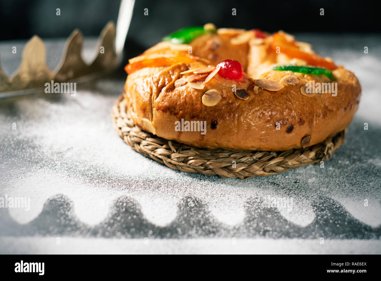 Primo piano di un Roscon de Reyes, spagnolo dei tre re torta mangiata il giorno dell'Epifania, su un livello di grigio tavolo rustico Foto Stock