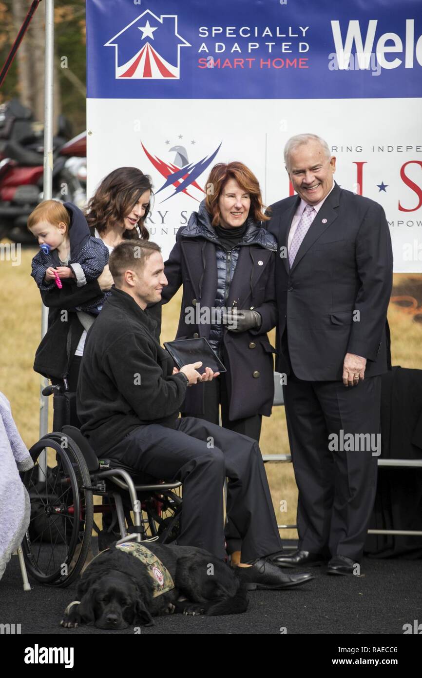 Ritirato U.S. Marine Corps Cpl. Garrett Jones riceve un iPad da Bob Pence, membro del consiglio di amministrazione, Gary Sinise Foundation e sua moglie, che avrà il controllo della sua nuova casa durante la Smart Home inaugurazione in Stafford, Virginia, Gennaio 19, 2017. Jones ha ricevuto la casa dalla Gary Sinise Foundation, che iniziò a costruire appositamente adattato le case intelligenti per l'America gravemente feriti veterani attraverso i suoi programmi per i partner in 2012. Foto Stock