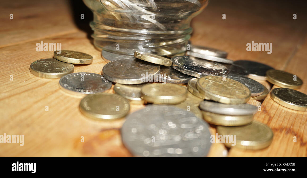 Prendendo delle monete dal vaso di risparmio Foto Stock