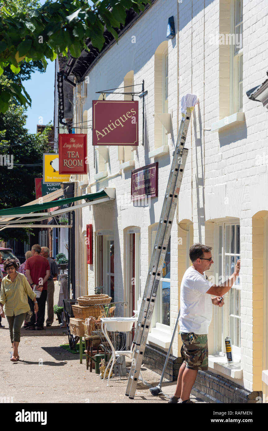 Pittore decoratore lavorando presso i bygones di Long Melford negozio di antiquariato, Hall Street, Long Melford, Suffolk, Inghilterra, Regno Unito Foto Stock