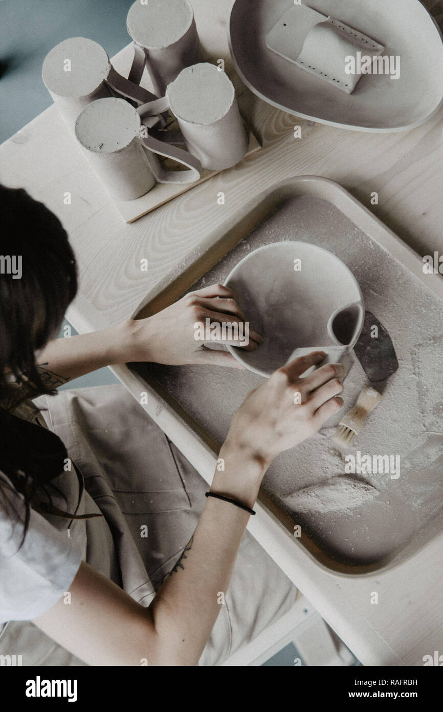 Donna fare ceramica. Vista dettagliata del processo di levigatura a piastra di argilla Foto Stock