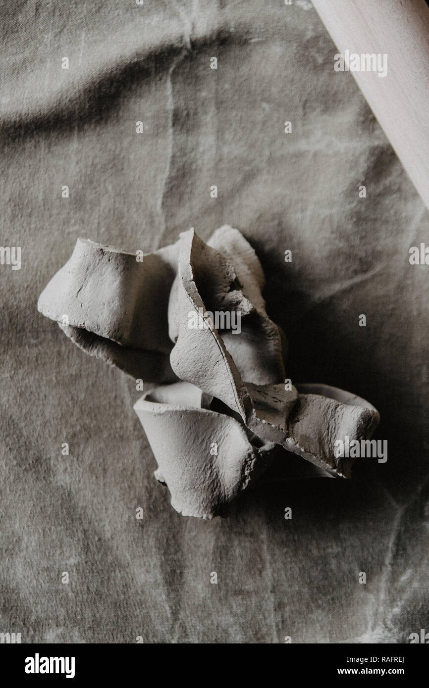 Un pezzo di argilla sul tavolo. Artigianali fatti a mano sullo sfondo. Foto Stock