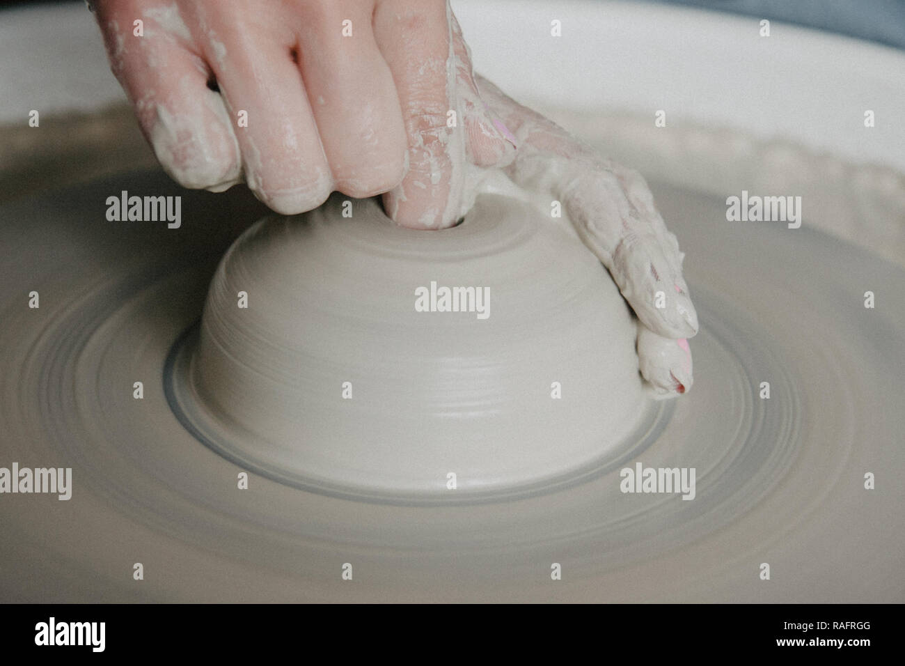 Creazione di un vaso o in un vaso di argilla bianca di close-up. Donna mani rendendo brocca di argilla su potter ruota. Foto Stock