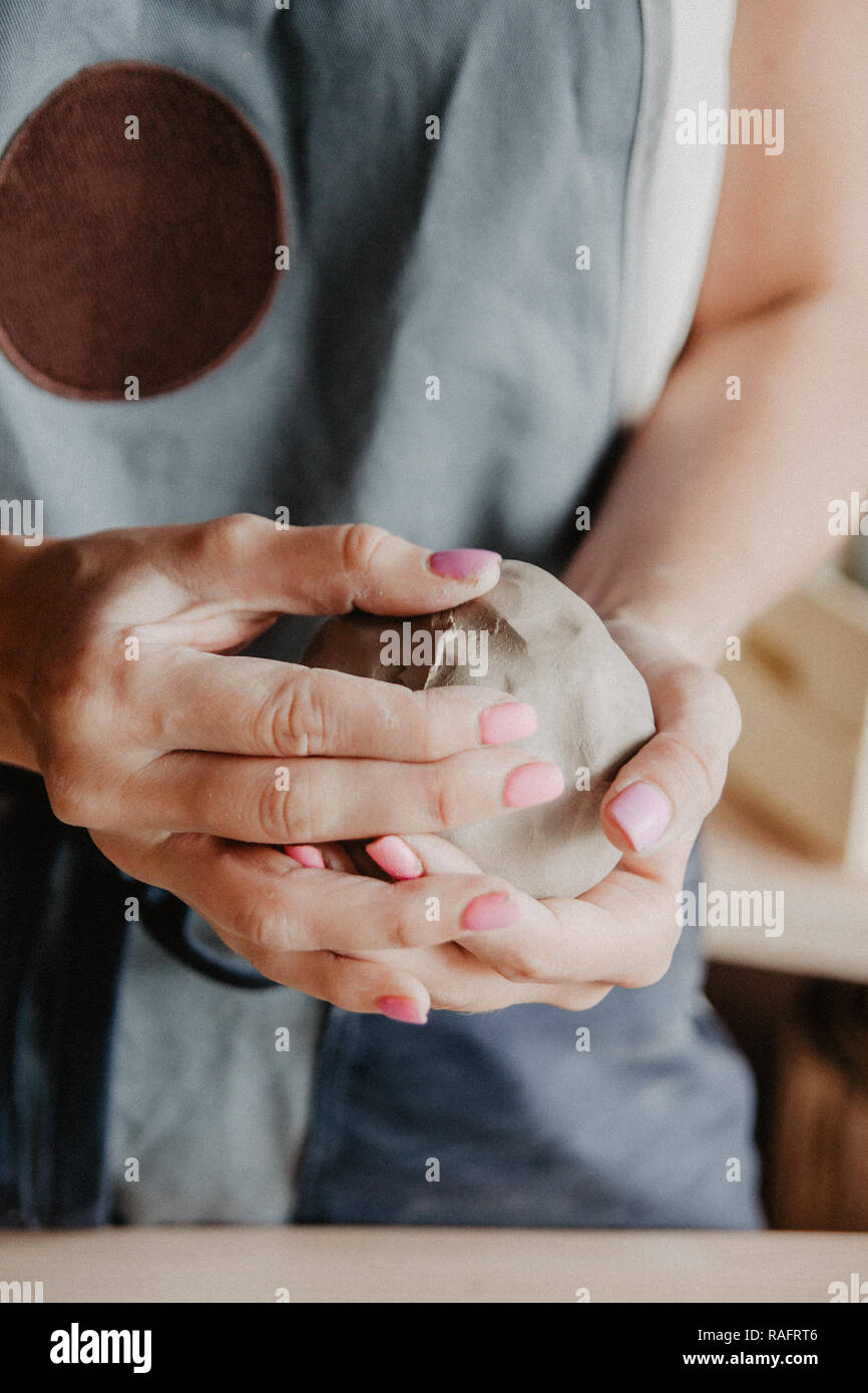 Ceramiche, argilla, arte ceramica concetto, Primo piano sulle mani del giovane maestro con pezzi grandi di terra refrattaria Foto Stock