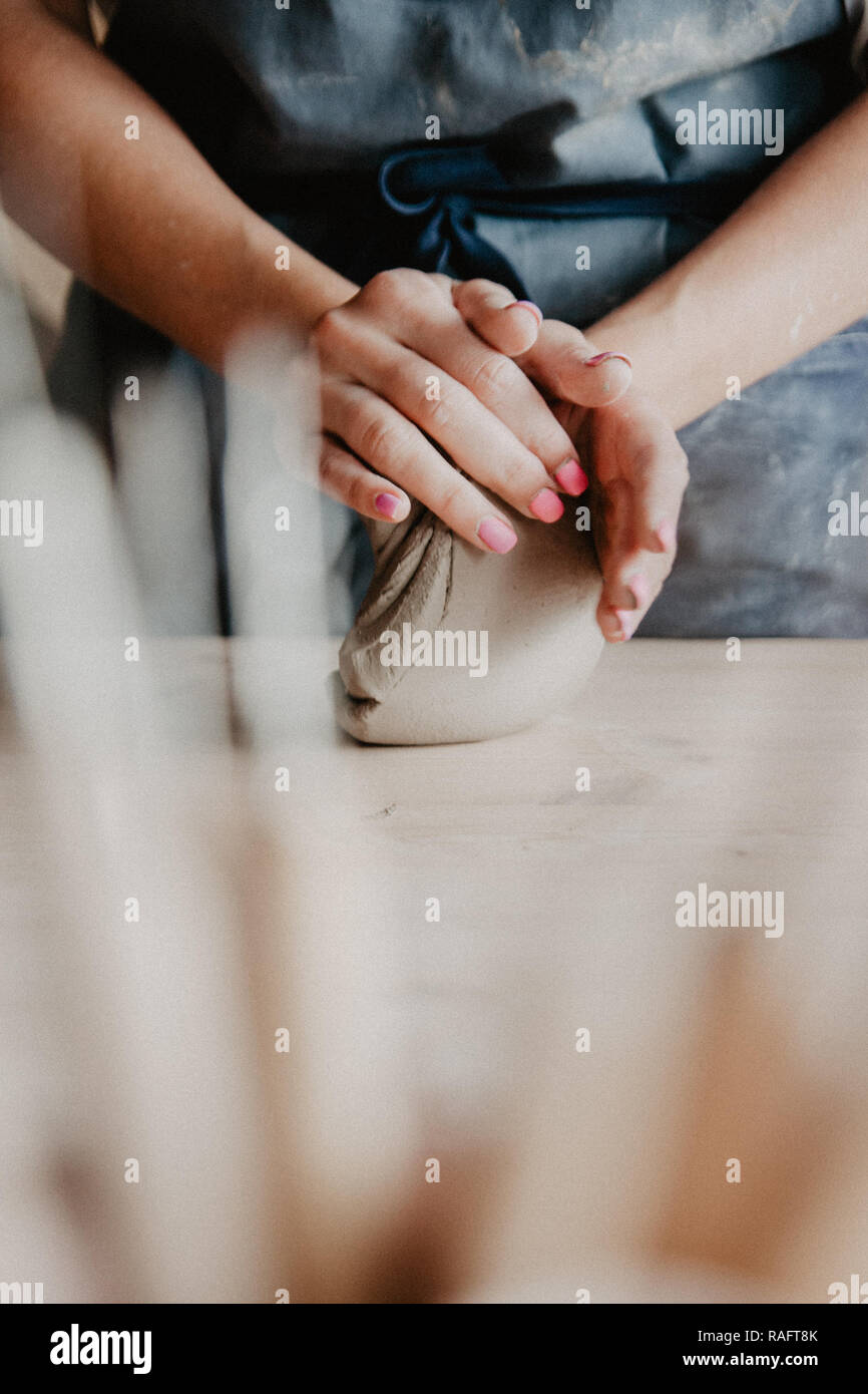 Ceramiche, argilla, arte ceramica concetto, Primo piano sulle mani del giovane maestro con pezzi grandi di terra refrattaria Foto Stock