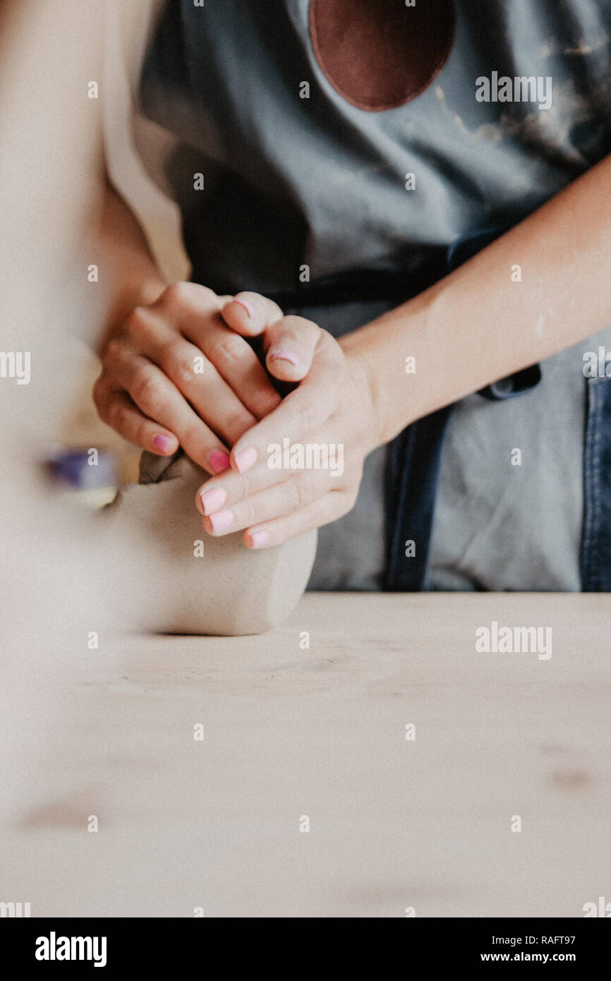 Ceramiche, argilla, arte ceramica concetto, Primo piano sulle mani del giovane maestro con pezzi grandi di terra refrattaria Foto Stock